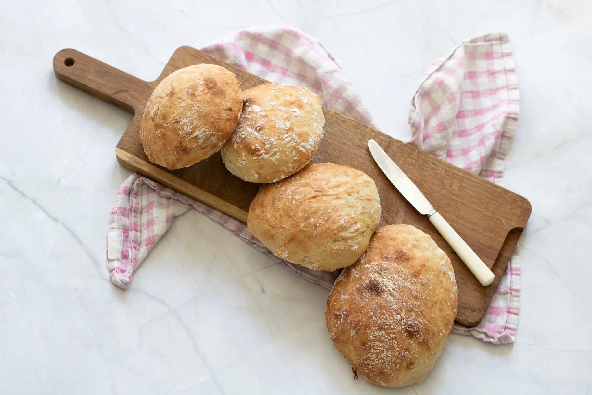 Rustic panini breads on a wooden board